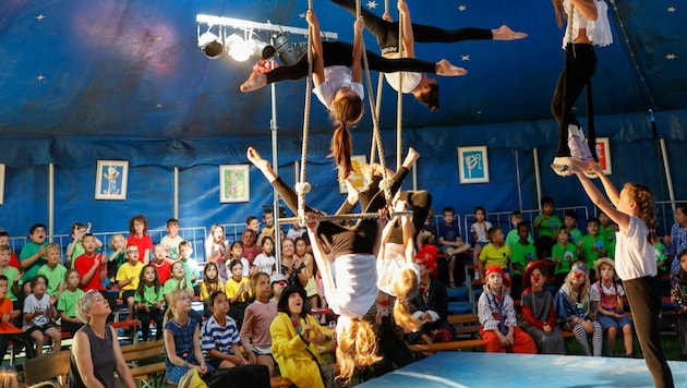 In schwindelerregender Höhe führen einige der Schüler der Volksschule am Trapez ihre Akrobatik-Künste vor. (Bild: Tschepp Markus)