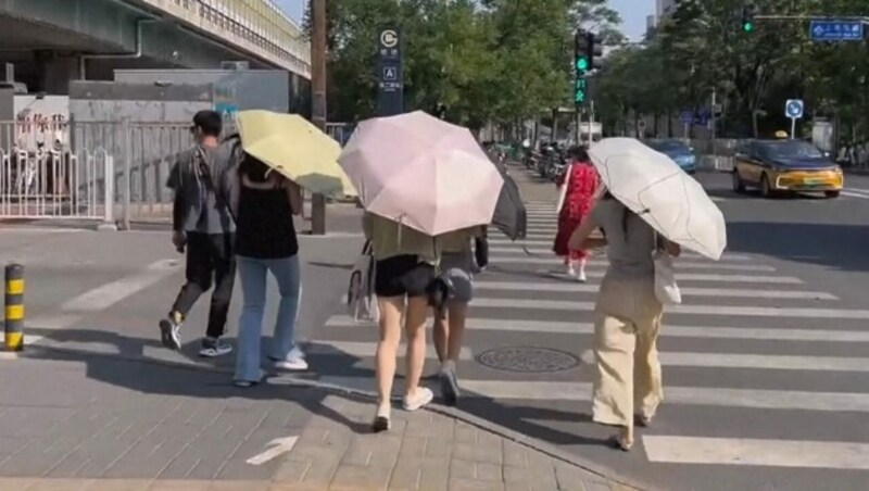 Der Norden Chinas leidet zurzeit unter extremer Hitze. Schirme bieten zumindest Schutz vor der prallen Sonne. (Bild: kameraOne)