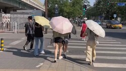 Chinesinnen schützen sich mit Schirmen vor der prallen Sonne. (Bild: kameraOne)