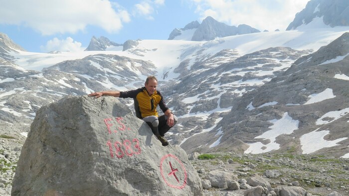 Meteorologe und Glaziologe Klaus Reingruber beim Simonystein. Dieser wurde vom Geographen, Alpinisten und Forscher Friedrich Simony im Jahr 1883 an der Gletscherzunge gesetzt - jetzt ist diese weit im Hintegrund zu erkennen