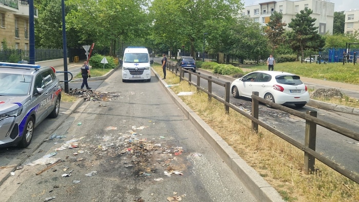 Nicht weit außerhalb der „sicheren“ Grenzen der Innenstadt räumt die Polizei die verbrannten ...