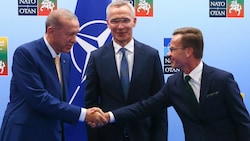 Der türkische Staatschef Recep Tayyip Erdogan (links) schüttelt die Hand des schwedischen Ministerpräsidenten Ulf Kristersson. In der Mitte: NATO-Generalsekretär Jens Stoltenberg (Bild: ASSOCIATED PRESS)