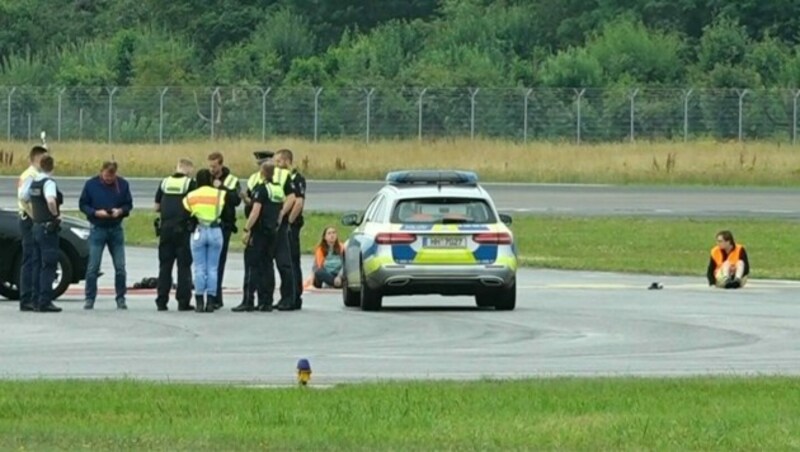 Kleben am Flughafen: Die „Letzte Generation“ streikte in Hamburg (Bild) und Düsseldorf. (Bild: AFP)