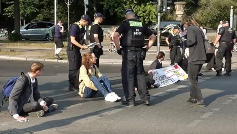 Mal wieder Stillstand im morgendlichen Berufsverkehr: Klimaaktivisten der Gruppe „Letzte Generation“ haben am Freitag an mehreren Stellen in Berlin den Verkehr blockiert. (Bild: Screenshot/glomex.com/dpa)