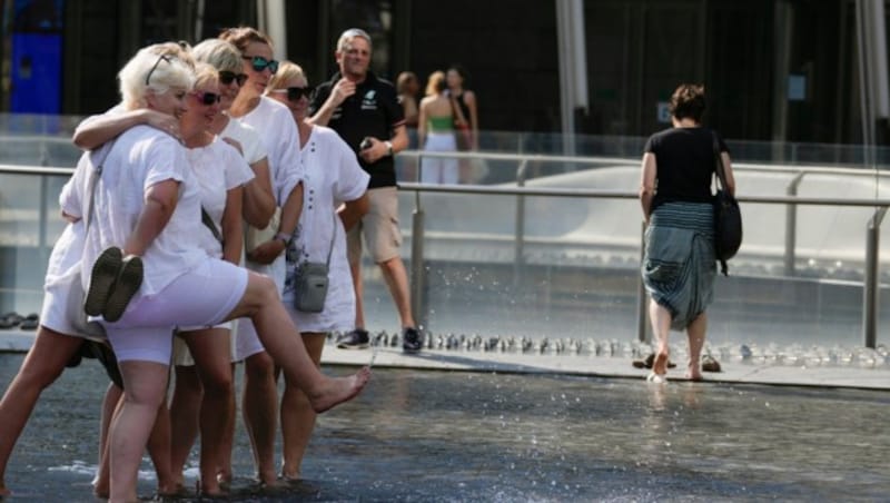 Diese Touristinnen in Mailand sind nach einer Abkühlung in einem Brunnen bei bester Laune. (Bild: Associated Press)