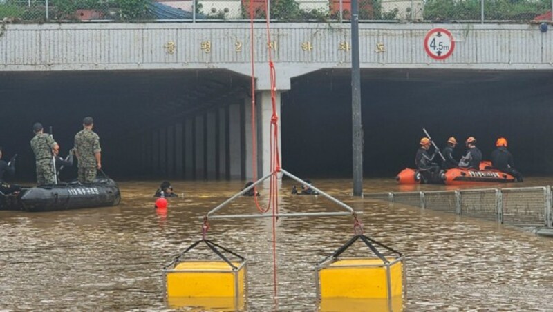 Ein Straßentunnel in Cheongju ist wegen des starken Regens mit Wasser vollgelaufen. Die Feuerwehr sucht nach Opfern. (Bild: APA/South Korea National Fire Agency via AP)