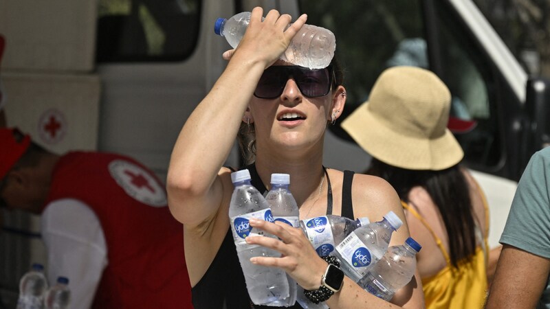 Diese Frau in Griechenland hat sich mit reichlich Wasser eingedeckt, um die Hitze zu überstehen. (Bild: AFP)