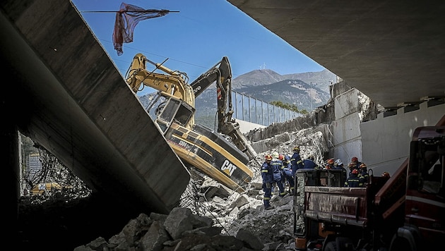 Rettungskräfte an der eingestürzten Brücke suchen nach weiteren Opfern. (Bild: AFP)