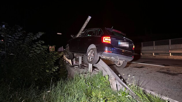 Der Pkw blieb auf der Leitschiene hängen und krachte gegen einen Eisenpfahl. (Bild: zoom.tirol, Krone KREATIV)