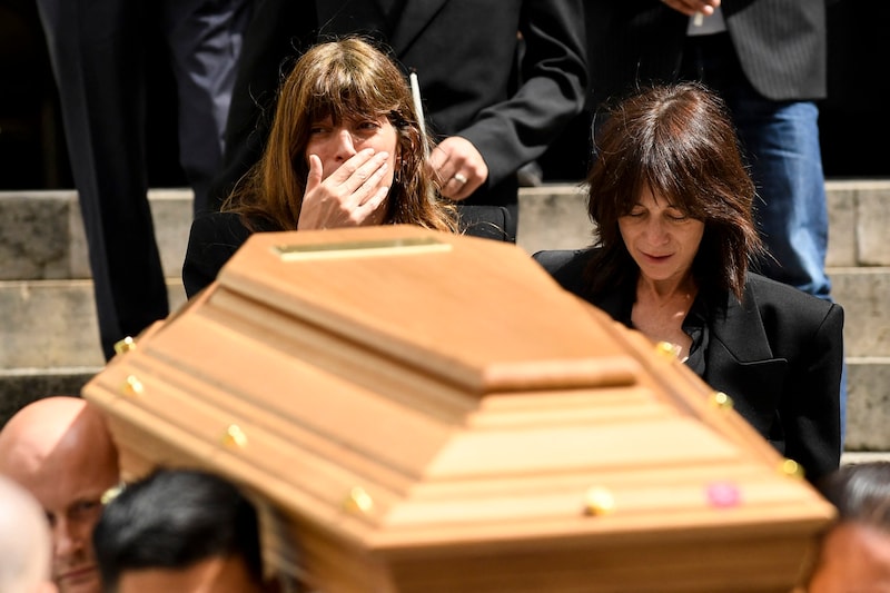 Genau wie ihre Mutter, ließe sich Lou Doillon (links) und Charlotte Gainsbourg (rechts) von veralteten Gepflogenheiten nicht abschrecken und halfen beim Tragen des Sarges mit. (Bild: APA/AFP/JULIEN DE ROSA)