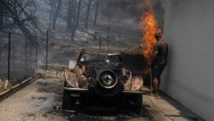 Ein Bewohner auf Rhodos versucht, die Flammen zu löschen (Bild: The Associated Press)