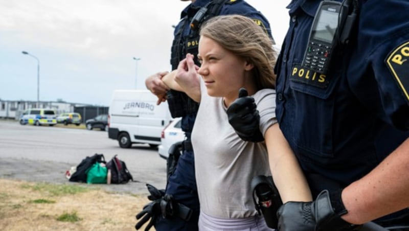 Greta Thunberg wird während des Protests in Malmö von Polizisten von der Straße getragen. (Bild: AP)