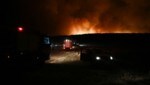 Feuerwehrfahrzeuge sind zu sehen, während Rauch von einem Waldbrand in der Nähe der Stadt Volos in Mittelgriechenland aufsteigt. Neue Brände veranlassen die Bevölkerung, das Industriezentrum der Stadt zu verlassen. (Bild: AFP)