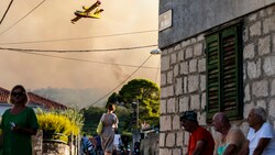 Ein Flugzeug versprüht Wasser, um den Waldbrand auf der Insel Ciovo zu löschen. (Bild: The Associated Press)