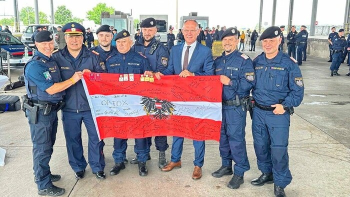 Takàcs (2. v. li.) und Karner (3. v.re.) unterzeichneten rotweißrote Operation-Fox-Flagge.