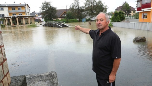 Lukas Bozic deutet auf die im Wasser versinkende Brücke im Valentin-Leitgeb-Park. (Bild: Rojsek-Wiedergut Uta)