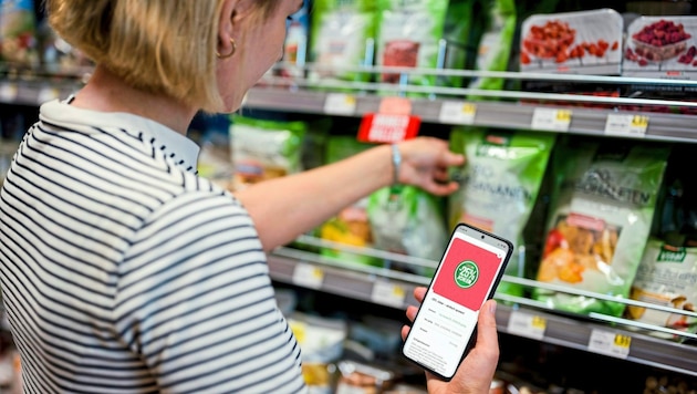 Konsumenten zeigen an der Kassa ihr Handy für Rabatte. (Bild: MIRIAM MEHLMAN)