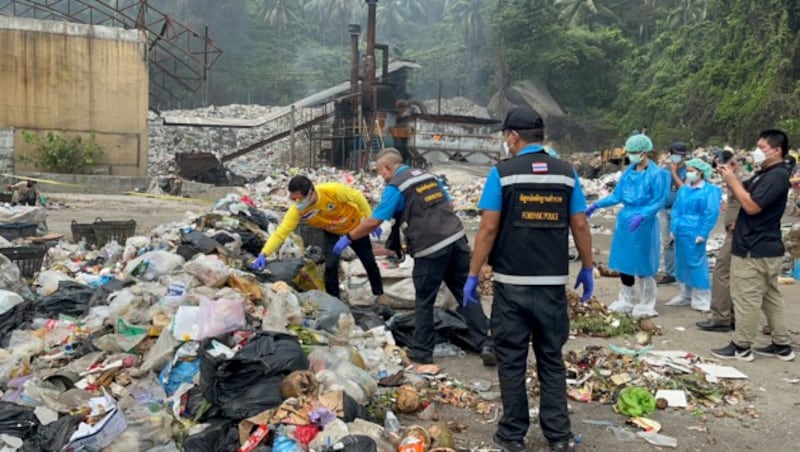 Thailändische Forensiker durchwühlen eine Müllhalde. (Bild: APA/AP Photo/Somkeat Ruksaman)