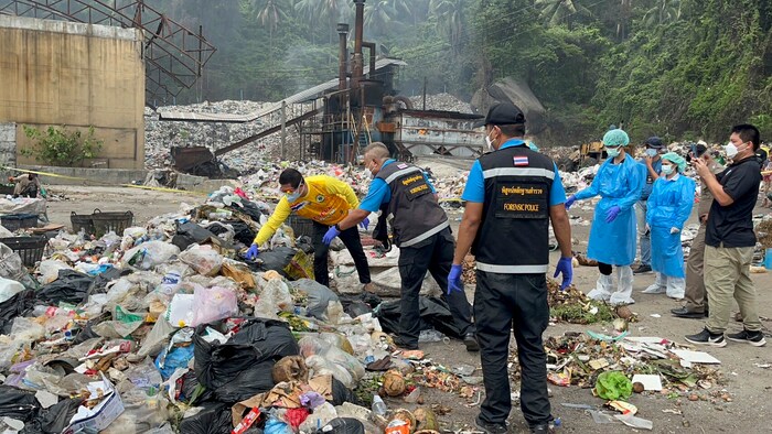 Thailändische Forensiker durchwühlen eine Müllhalde.
