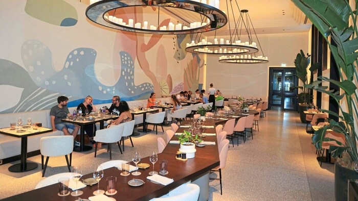 An der großen Tafel in der Mitte lässt es sich fein dinieren und in Kontakt mit anderen Gästen ...