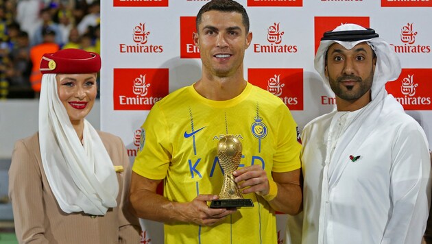 Cristiano Ronaldo und die Mini-Version der berühmten WM-Trophäe. (Bild: APA/AFP/Abdullah Mahdi)