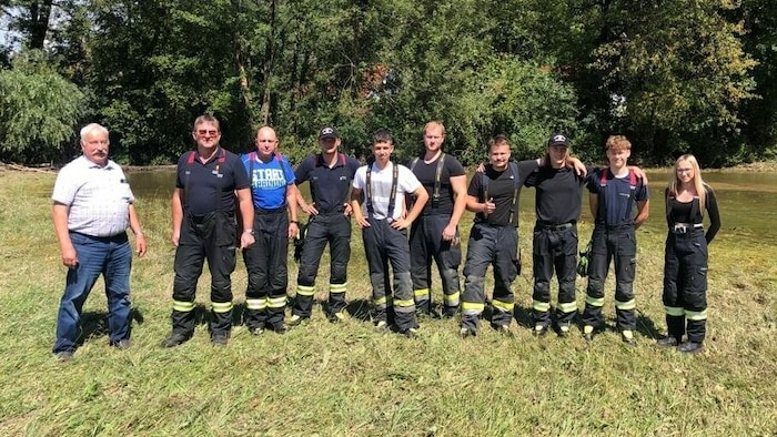 Aufsichtsfischer Karl Sakl mit der Feuerwehr Eberndorf vor dem Feld.