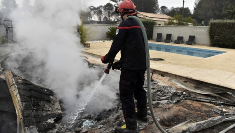 Feuerwehrleute kämpfen weiterhin gegen die Flammen. (Bild: APA/AFP/RAYMOND ROIG)