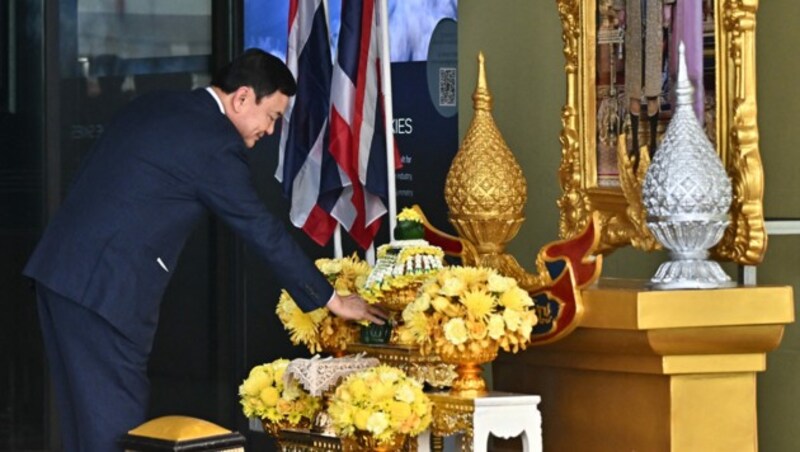 Thaksin verbeugte sich nach seiner Rückkunft vor einem Bild des thailändischen Königs. (Bild: AFP)