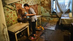 Eine Frau kocht in Tver, 200 Kilometer nordwestlich von Moskau gelegen, in einer heruntergekommenen Unterkunft für Arbeiter. (Bild: AFP)