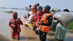 Mit Booten werden Menschen in Pakistan vor den Überschwemmungen in Sicherheit gebracht. (Bild: AP)