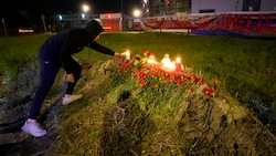 Vor dem ehemaligen Wagner-Hauptquartier in St. Petersburg legen Menschen Blumen und Kerzen nieder. (Bild: AP)