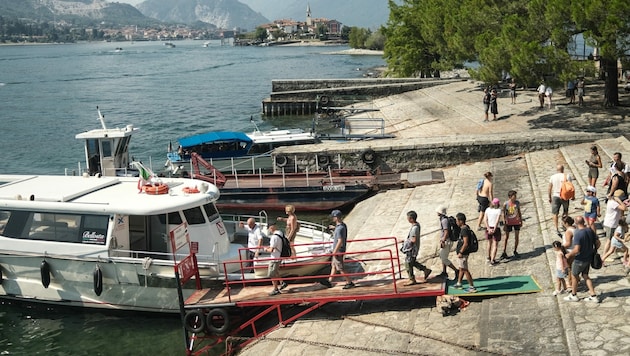 Menschen besteigen eine kleine Fähre auf der Isola Bella in Stresa am Lago Maggiore, wo der Wasserstand aufgrund der Trockenheit niedrig ist und einen Teil der Touristenschifffahrt einschränkt. (Bild: AFP)