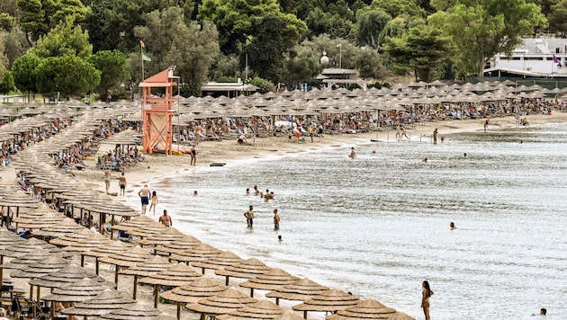 Mit dem Slogan „Wir wollen den Strand zurück“ protestieren die Einwohner von Paros gegen „gierige“ Strandbars, die illegal Sonnenliegen am Strand aufstellen und damit den öffentlichen Strand an sich reißen. (Bild: AFP/Spyros BAKALIS)