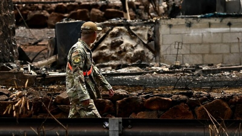 Ein Mitglied der US-Nationalgarde schreitet durch vollkommen niedergebrannte Viertel. (Bild: APA/AFP/Patrick T. Fallon)