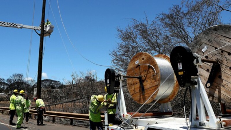 Arbeiter des Stromversorgers Hawaiian Electric führen Reparaturarbeiten durch. (Bild: APA/Getty Images via AFP/GETTY IMAGES/JUSTIN SULLIVAN)