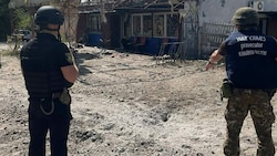 Staatsanwälte für Kriegsverbrechen untersuchen am Samstag das ukrainische Dorf Podoly in der Nähe der Stadt Kupjansk in der Region Charkiw. (Bild: APA/AFP/Office of the Prosecutor General of Ukraine/Handout)