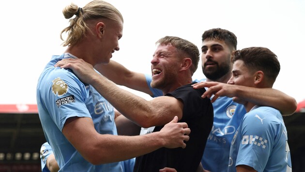 Da gab‘s offenbar eine Sicherheitslücke im Stadion: Nach einem Tor von Erling Haaland jubelte ein prominenter Fan mit dem Norweger hautnah mit. (Bild: APA/AFP/Darren Staples)