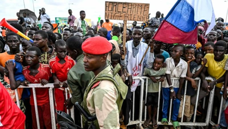 Wütende Demonstranten mit russischen Flaggen fordern den Abzug französischer Truppen aus dem Niger. (Bild: APA/AFP)