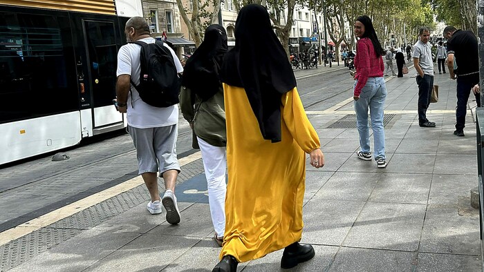 Eine junge Muslima in Marseille mit einer gelben Abaya