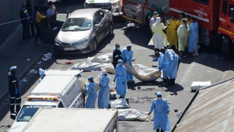 Vor dem Gebäude im zentralen Geschäftsviertel von Johannesburg waren zahlreiche zugedeckte Leichen zu sehen. (Bild: APA/AFP/Guillem SARTORIO)