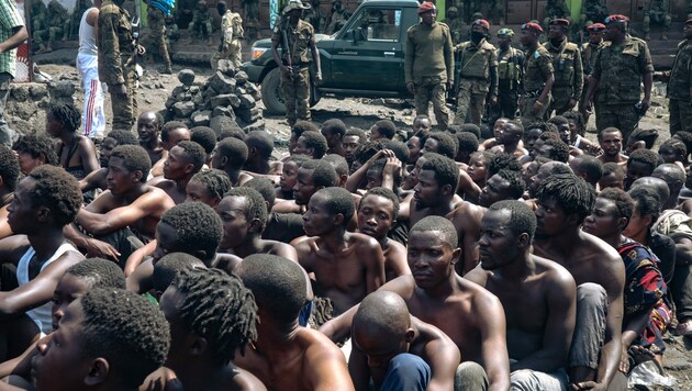 Zahlreiche Menschen wurden verhaftet, um eine Demonstration gegen die Vereinten Nationen zu verhindern. Sie sitzen am Boden und werden von der Armee bewacht. (Bild: APA/AFP)