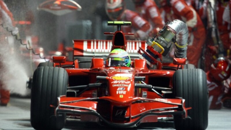 Der Boxenstop, der danebenging und indirekt Sportgeschichte schrieb: Felipe Massa fährt beim Nachtrennen 2008 in Singapur aus der Box - und nimmt den Tankrüssel mit. (Bild: AP)