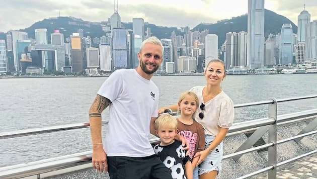 Jakob Jantscher mit Gattin Andrada und den Kindern Alma und Finn vor der Skyline von Hongkong (Bild: Jantscher)