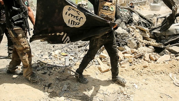 Archivbild aus dem Jahr 2017: Irakische Sicherheitskräfte mit einer umgedrehten IS-Flagge (Bild: APA/AFP/AHMAD AL-RUBAYE)