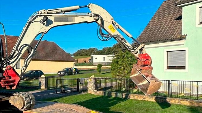 Die Schaufel von dem Bagger, der auf einem Tieflader stand, schwenkte in die falsche Richtung ...