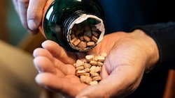 Ein belgischer Zollbeamter öffnet eine Flasche mit Ecstasy-Pillen bei der Kontrolle von Paketen am Brüsseler Flughafen. (Bild: AFP)