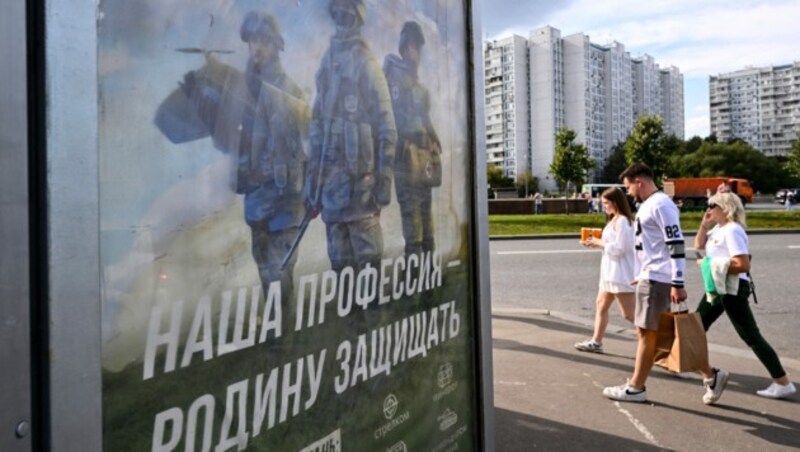 Russland sucht überall nach Kämpfern für seinen blutigen Angriffskrieg. Auf der Reklame in einem Moskauer Wohnviertel steht: „Unser Beruf ist es, das Vaterland zu verteidigen“. (Bild: APA/AFP/NATALIA KOLESNIKOVA)