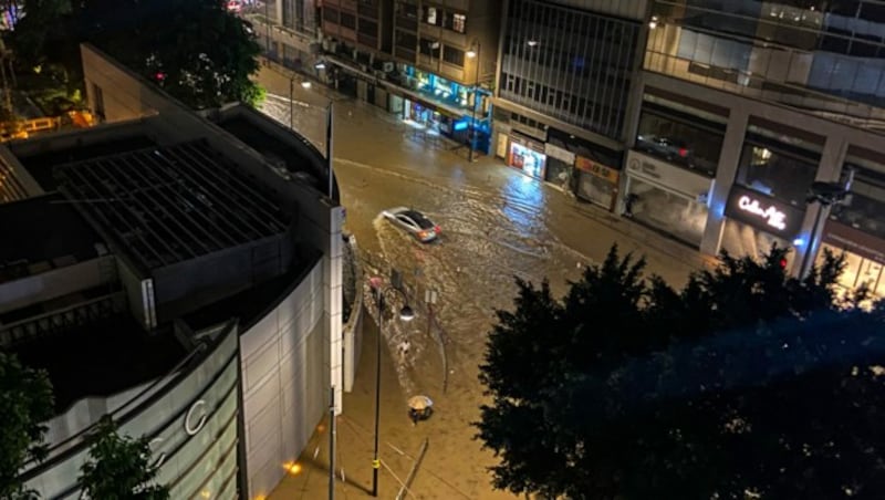 Autos kämpfen sich durch die Fluten. (Bild: APA/AFP/Dene CHEN)