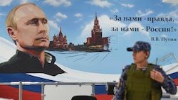 Auf der Wand eines Wahllokals steht: „Die Wahrheit und Russland sind auf unserer Seite! W. W. Putin“ (Bild: APA/AFP)