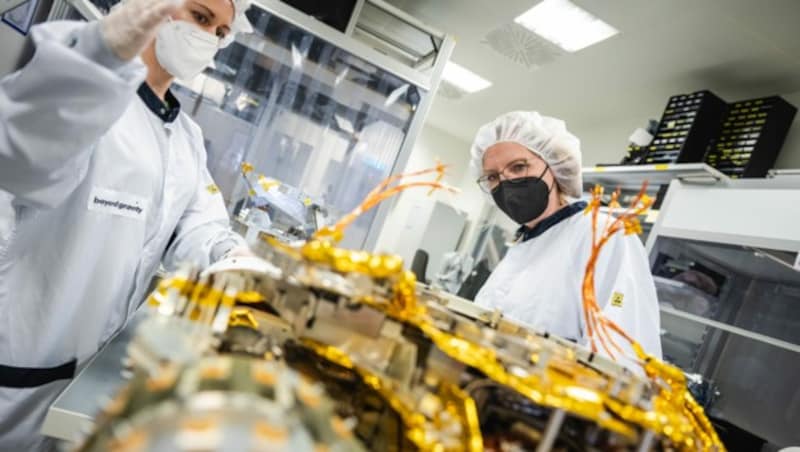 Klimaschutzministerin Leonore Gewessler (rechts) besuchte im April 2022 die Weltraumelektronikproduktion in einem Reinraum von Beyond Gravity Austria in Wien. (Bild: BMK/Perwein)